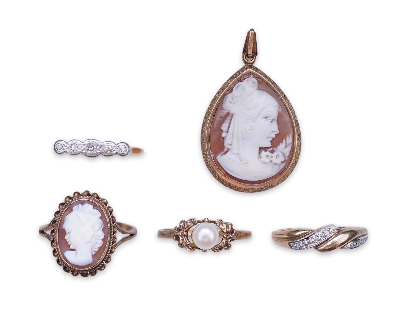 A collection of four rings and a pendant
